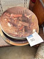 Stack of Rockwell plates, top shows grandfather and children illustration