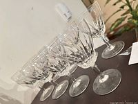 Six of the eight clear cut-crystal wine glasses lined up showing full shape