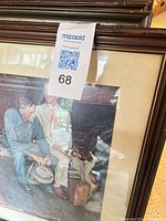 Close view of one Rockwell print with older man, boy, collie dog in brown frame