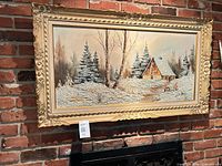 framed winter scene oil painting on brick wall