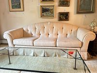 Front view of cream faux silk sofa showing overall style and skirt