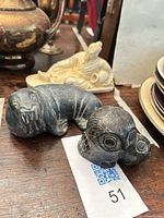 Stone walrus and owl sculptures with Chinese carving visible behind