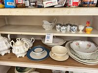 Shelf of assorted porcelain and glass tableware