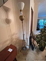 Full view of tall brass floor lamp with milk glass shade