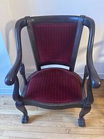 Front view of dark wood accent chair with red pinstripe upholstery