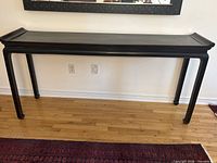 Front view of black console table against wall