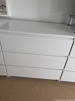 Front view of the white 3-drawer dresser showing drawer configuration and finish
