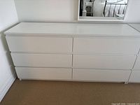 Front view of white six-drawer dresser