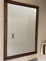 Front view of rectangular wood framed mirror on wall