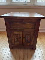 Front view showing drawer, carved dual doors and overall condition