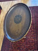 Top view showing oval surface with painted floral design and distressing