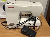 Side view of Janome SUV1108 sewing machine with cords and foot pedal