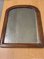 Front view showing entire arched mirror and wooden frame