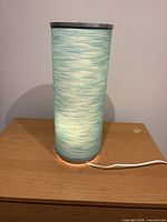 Lamp illuminated on tabletop showing turquoise glow