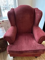 Front view of burgundy wing back chair showing upholstery and cushion