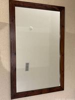 vertical view of rectangular mirror showing wood frame and glass