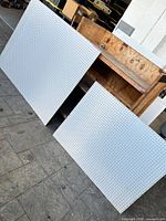 Both pegboard panels leaning against a wooden workbench