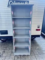 Front view of grey solid wood shelf showing five shelves