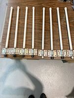 Eight identical white rod antennas aligned on table showing full length and mounting brackets