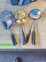 Three packaged badminton racket sets laid on table