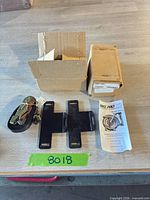 One open box with mounting plates, ratchet strap, instructions; sealed second box visible