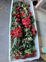 Top view of tote showing artificial evergreen garlands with red bows, poinsettias and ornaments
