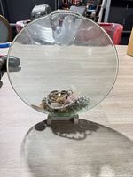 Front view of glass vase standing on table with jewelry inside