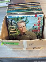 Box containing multiple Jimmy Swaggart LPs, front record “At an Altar of Prayer” visible