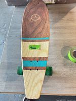 Full view of deck showing rear wheels, striped design, missing front truck