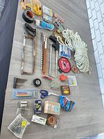 Overhead view showing hacksaws, circular blade, rope, drill bits, hardware