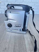 Left side view showing Innovage Outdoor branding, control knobs, lantern panel, handle