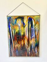 Front view of stained glass panel hanging against white wall