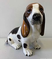 Front left view of glazed ceramic basset hound figurine showing overall form and coloration