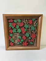 Front view of framed carved wood maple leaf relief