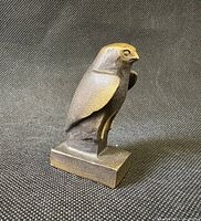 angled side view of bronze Horus falcon on plinth