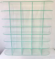 Front view of acrylic display stand showing grid cubbies and rounded edges
