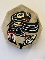 Front view of octagonal elk hide drum with Indigenous raven and fish painting