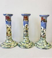 Front view of three matching porcelain candlesticks showing ship motif and lustre glaze