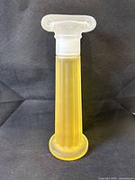 Full view of satin glass column bottle on dark backdrop