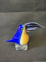 Front view of multicolored Murano glass toucan on clear base