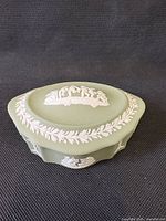 Full view of box with lid showing white relief and laurel border