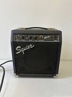 Front view of Squier SP-10 amplifier showing grille, logo and control panel