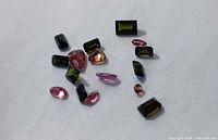 Group of 16 assorted faceted tourmalines on white background