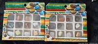 Front view of two identical Stone Charms boxes showing 12 assorted gemstone pendants in each