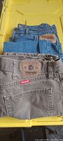 Stack of three jeans showing Wrangler patch, Dakota label, Mountain pair