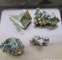 Four bismuth crystals on scale top view