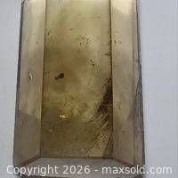 Front view of polished quartz point showing smoky coloration and inclusions