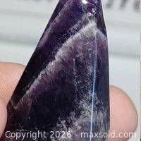 Front view of polished chevron amethyst pendant showing banding and drilled hole