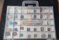 full view of plastic case showing compartments and stones