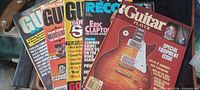 All five guitar magazines fanned out showing covers